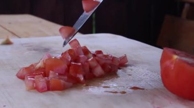 Büyük bir domatesi bıçakla dilimlemek. Yemek hazırlama. sebze