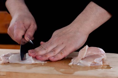 Tahta bir tahtada bıçakla eti parçalara ayırmak. Aşçı eti keser..