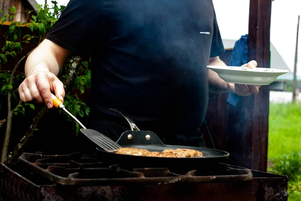 厨师在火堆上的锅子里烤切片 自然烤架上的食物 — 图库照片