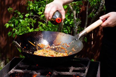 Tavaya soya sosu ekliyorum. Tavada sebze pişirmek.