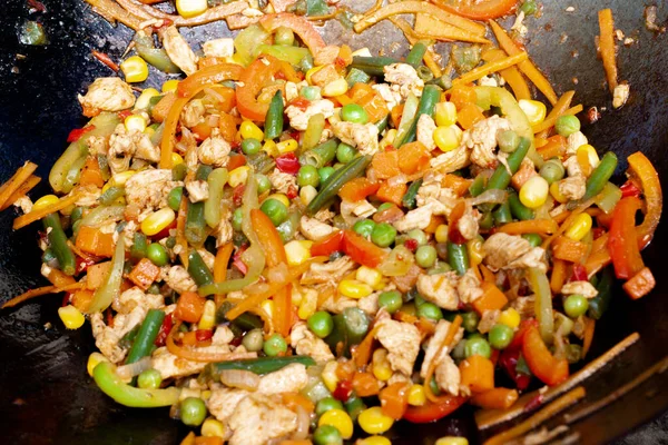 stock image vegetables fried with chicken in a wok pan.