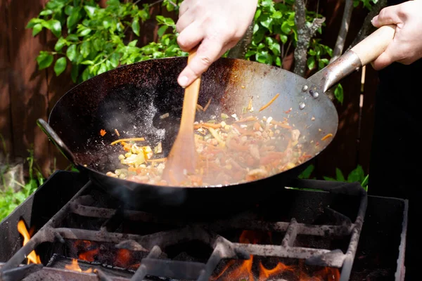 料理人は鍋に野菜と鶏で麺を準備します アジア料理 火の上で調理する — ストック写真