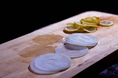 Aşçı ızgaraya soğanlı, limonlu ve otlu lezzetli kırmızı balık parçaları koyar.