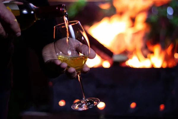 Barbekünün arka planına şömineli bir şişe beyaz şarap dök.