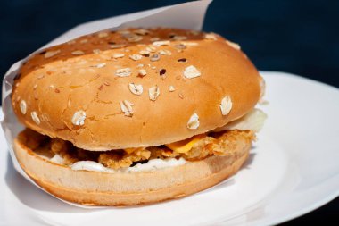 Tabağında pirzola olan ağız sulandıran bir hamburger. tohumlu çörek