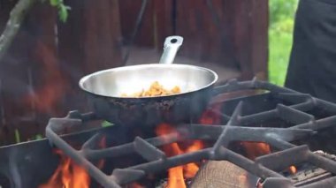 Bir adam eti şişte soğanla şişler..