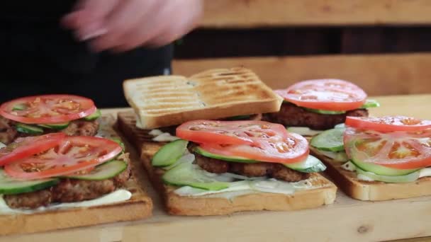 Cozinheiro Recolhe Sanduíches Com Costeleta Legumes — Vídeo de Stock