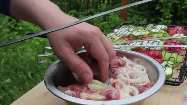 Ein Mann Spießt Fleisch Mit Zwiebeln Auf Einen Spieß — Stockvideo