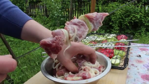 Ein Mann Spießt Fleisch Mit Zwiebeln Auf Einen Spieß — Stockvideo