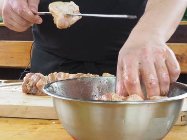 Aşçı et parçalarını baharat ve şiş sosla marine eder. Domuz göbeği