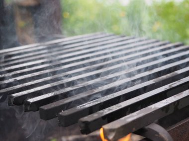Yağ sürülmüş ızgara ızgarası. Duman. Açık hava eğlencesi.