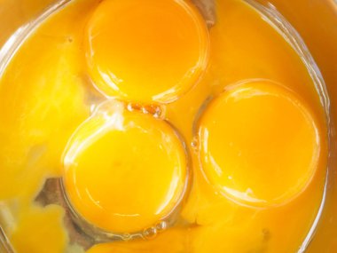 Bir kasede üç yumurta sarısı. Kahvaltı pişir. Sarıdan yapılmış bir gülümseme..