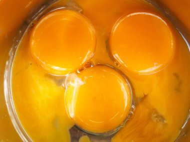 Bir kasede üç yumurta sarısı. Kahvaltı pişir. Sarıdan yapılmış bir gülümseme..