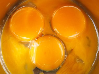 Bir kasede üç yumurta sarısı. Kahvaltı pişir. Sarıdan yapılmış bir gülümseme..