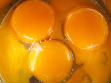 Bir kasede üç yumurta sarısı. Kahvaltı pişir. Sarıdan yapılmış bir gülümseme..