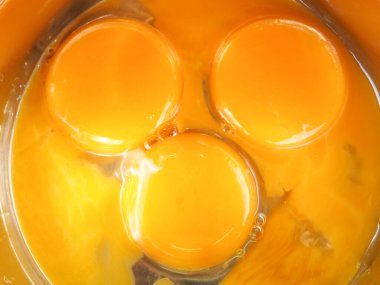 Bir kasede üç yumurta sarısı. Kahvaltı pişir. Sarıdan yapılmış bir gülümseme..