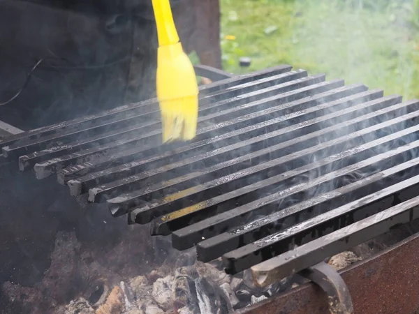 Yağ sürülmüş ızgara ızgarası. Duman. Açık hava eğlencesi.
