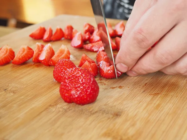 Aşçı ahşap bir tahtada büyük bir çilek keser. Poster. Yazın
