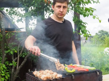 Aşçı ızgarada sebze ve et kızartır. Lezzetli yemek.