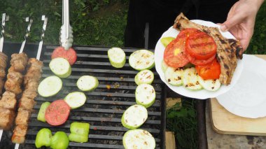 Aşçı ızgarada sebze ve et kızartır. Lezzetli yemek.