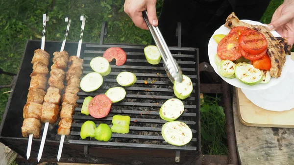 Cozinheiro Retira Verduras Carne Grelha Com Pinças Uma Chapa Comida — Fotografia de Stock