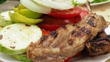 Aşçı sebzeleri ızgarada etle hazırlar. Ateşte kızarır. 4K video.