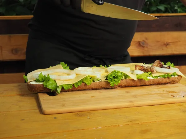 Chef Tranche Met Viande Sur Méga Sandwich Avec Des Feuilles — Photo