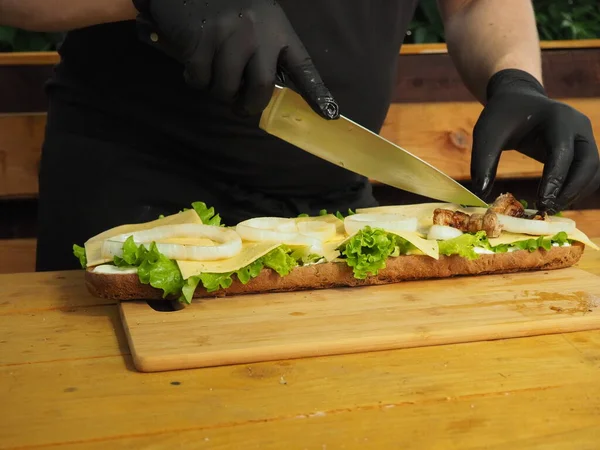 Chef Tranche Met Viande Sur Méga Sandwich Avec Des Feuilles — Photo