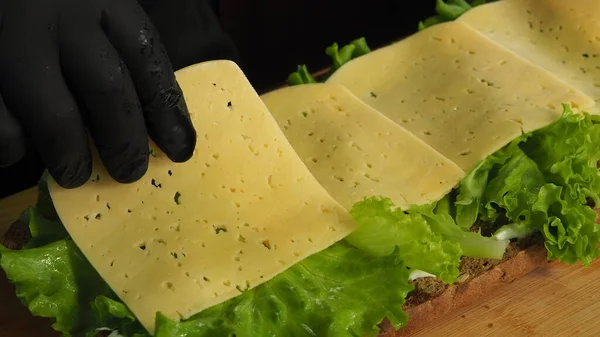 Cuoco Mette Foglie Lattuga Formaggio Con Anelli Cipolla Sul Pane — Foto Stock