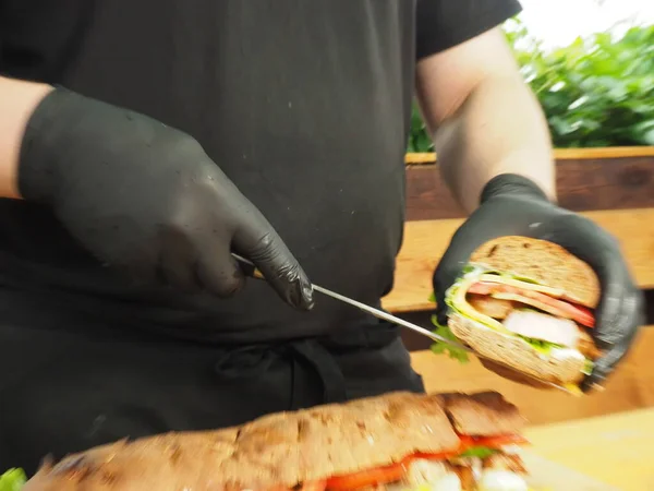 Kock Visar Ett Snitt Fransk Baguette Smörgås Med Grönt Ost — Stockfoto