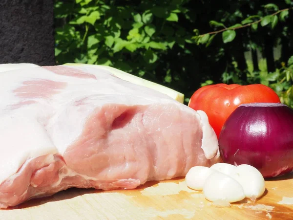 Schweinelende Auf Knochen Mit Knoblauch Und Gemüse Auf Einem Holzbrett — Stockfoto