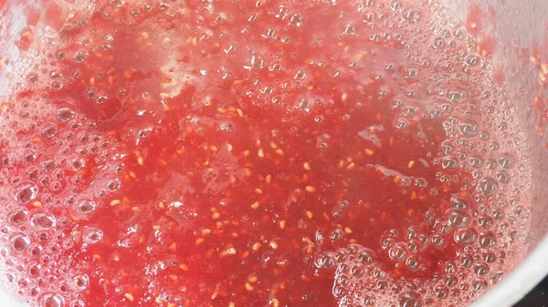 Aşçı ocağın üstünde ahududu reçeli pişiriyor. ahududu reçeli.