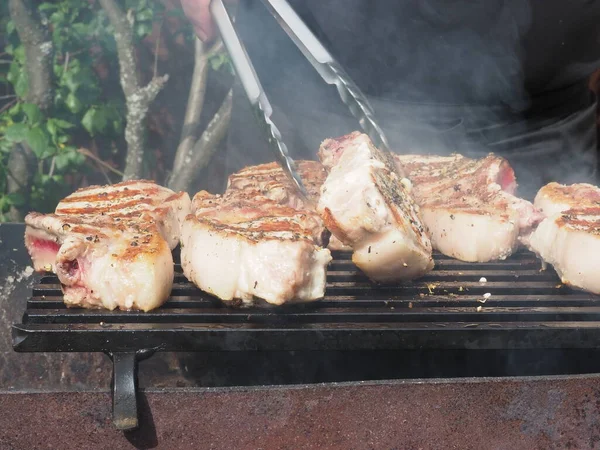 돼지고기 스테이크를 뒤집는다 사용하는 분쇄기 — 스톡 사진
