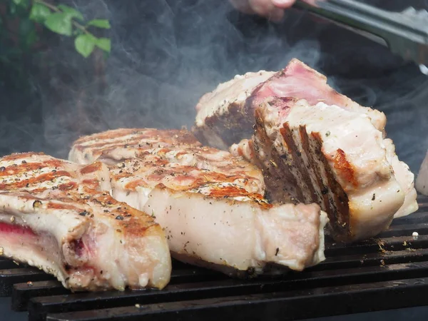 돼지고기 스테이크를 뒤집는다 사용하는 분쇄기 — 스톡 사진