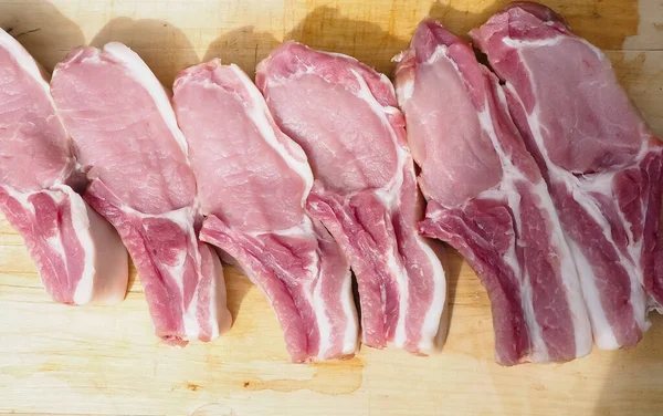 pork steaks on the bone on a wooden table . delicious pork loin steaks on the bone.