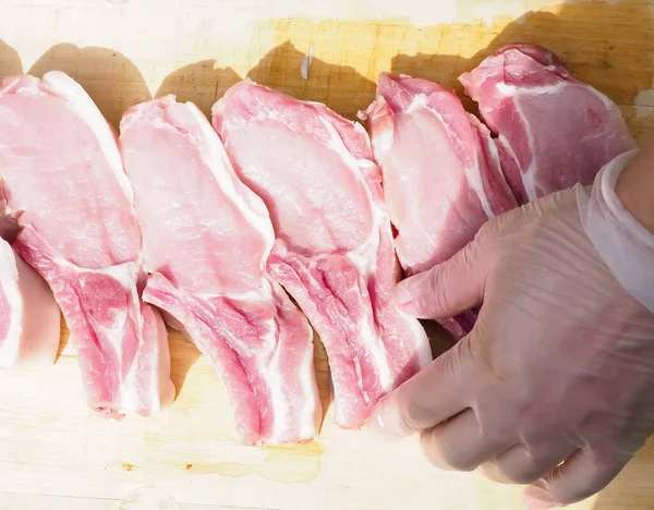 pork steaks on the bone on a wooden table . delicious pork loin steaks on the bone.