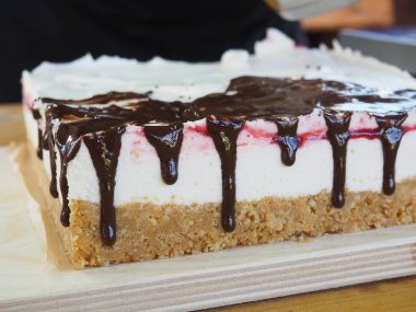 Pasta şefi lezzetli bir pastanın üzerine çikolata döküyor. Çikolata. Tatlının hazırlanması..