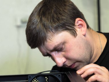 Genç bir adam kişisel bir bilgisayar yapıyor. Atölye. Onarım. bilgisayar durumu.