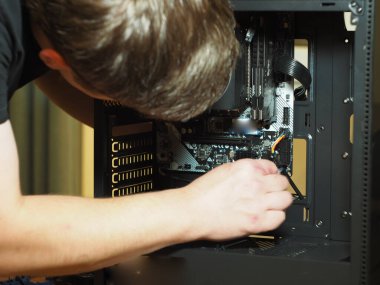 Genç bir adam kişisel bir bilgisayar yapıyor. Atölye. Onarım. bilgisayar durumu.