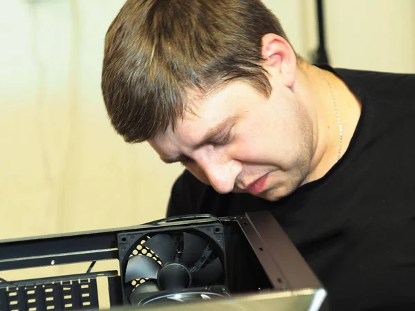 a young man builds a personal computer. workshop. repair. computer case.