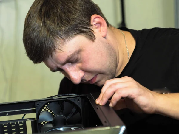 a young man builds a personal computer. workshop. repair. computer case.