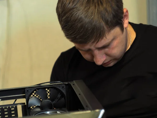 a young man builds a personal computer. workshop. repair. computer case.
