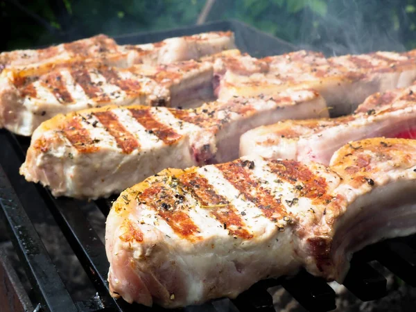 Izgarada kemikli biftekler. Kömürde pişirmek. Kemiklerdeki domuz eti.