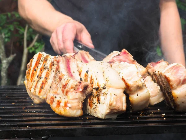 남자는 스테이크를 돌린다 석탄으로 요리하는 돼지고기 — 스톡 사진