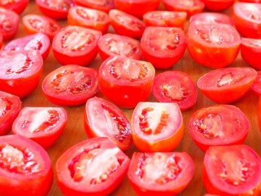Tahtada dilimlenmiş domates. Tatlı domatesleri kurutmak. Yazın tadı.