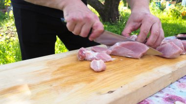 Tahtada bıçakla et kesmek. Taze domuz. Doğada yemek yapmak.