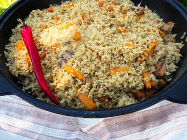 Kırmızı biberli bir kazanda pilav. et ve pirinç.