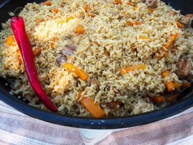 Kırmızı biberli bir kazanda pilav. et ve pirinç.