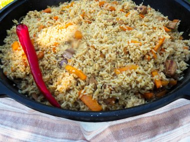Kırmızı biberli bir kazanda pilav. et ve pirinç.