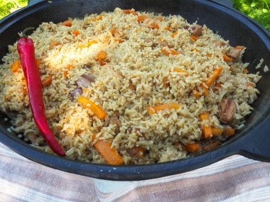 Kırmızı biberli bir kazanda pilav. et ve pirinç.